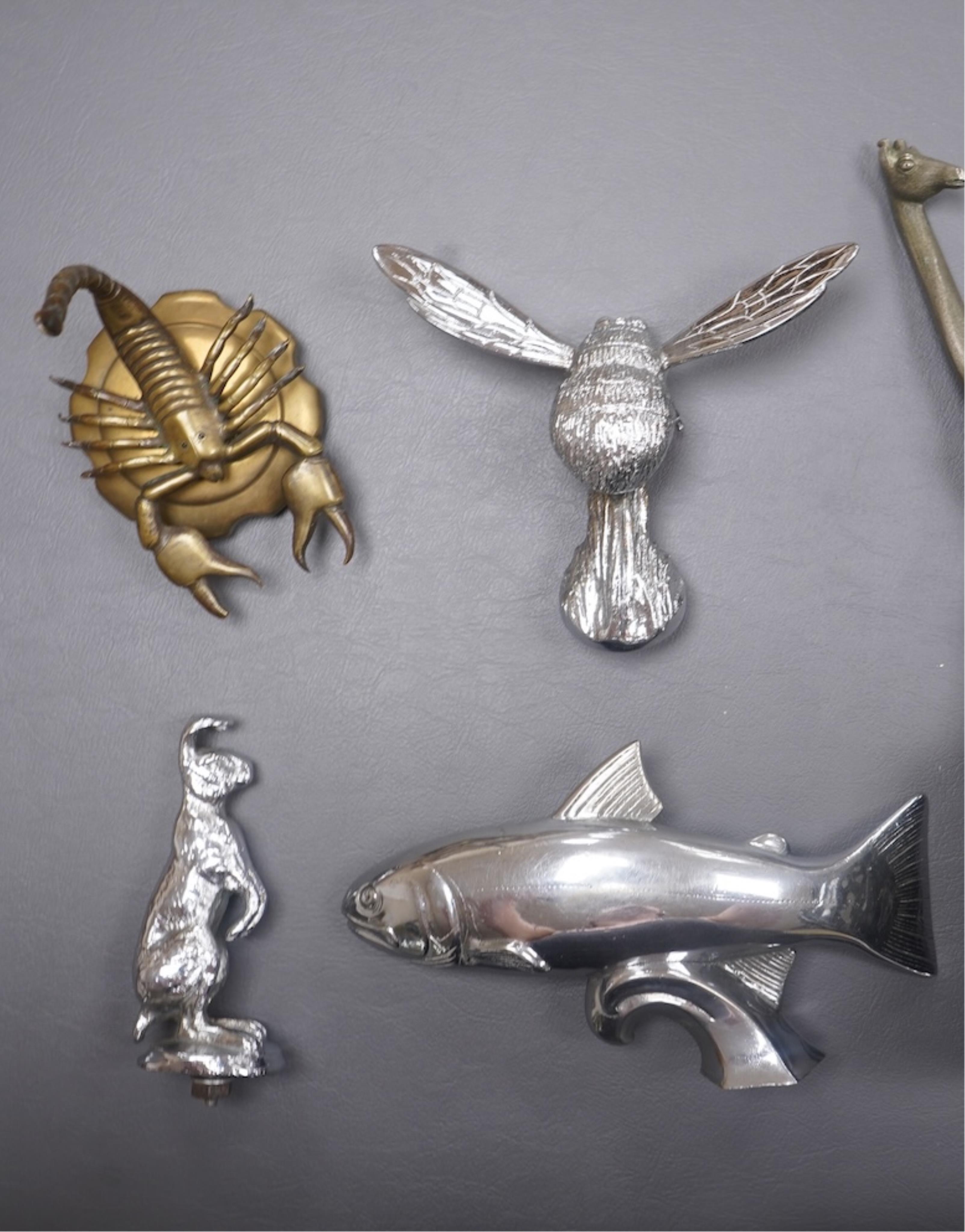 Five animal themed chrome and brass car mascots consisting of a giraffe mounted on a turned aluminium base, a hare, a bumblebee in flight, a leaping fish, and a scorpion. Condition - fair to good.